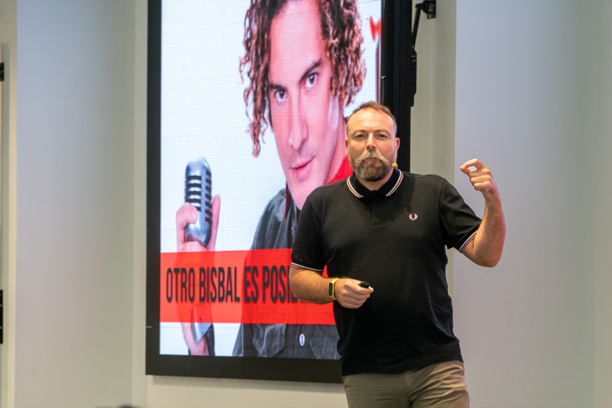 Pedro Bisbal en el escenario junto a una pantalla con David Bisbal y el rótulo «Otro Bisbal es posible»